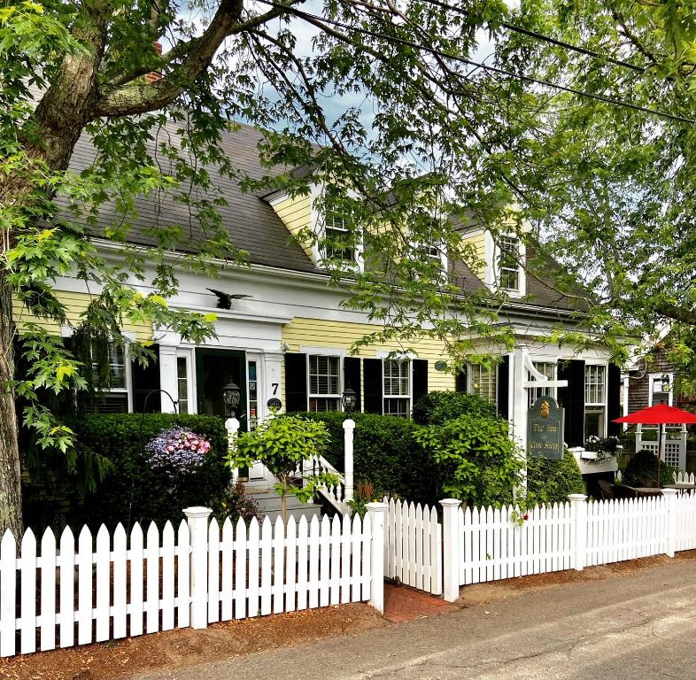 ein weißer Gartenzaun vor einem weißen Haus in der Unterkunft Inn at Cook Street in Provincetown