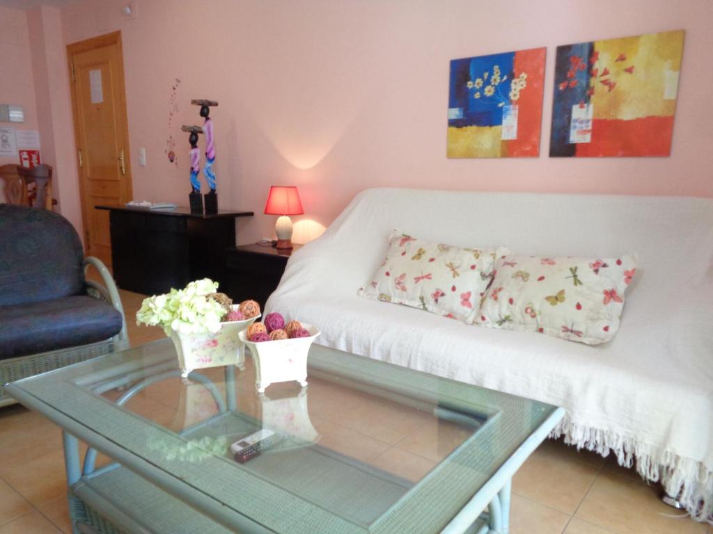 un soggiorno con divano e tavolo in vetro di Ada Edison Apartamento, Parking, Aire acondicionado, WiFi, Piscinas a Peñíscola