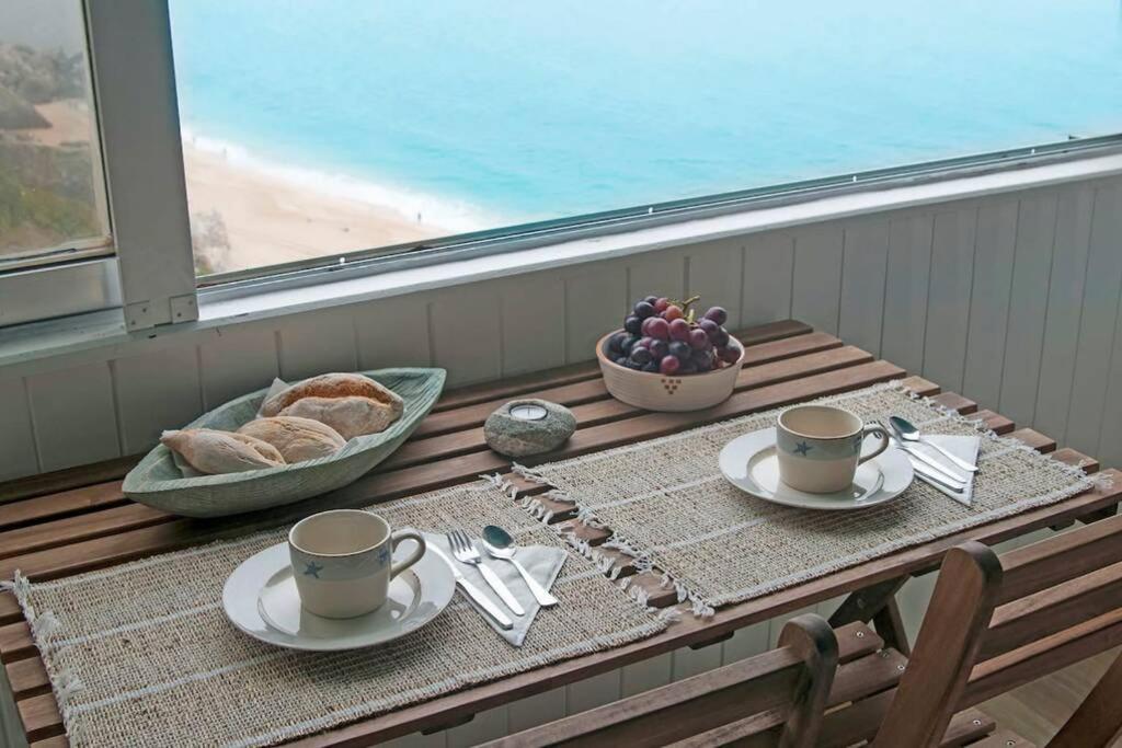 セジンブラにあるBlue Studio Sesimbra - Com acesso privado à praiaのコーヒー2杯とフルーツ1杯付きのテーブル
