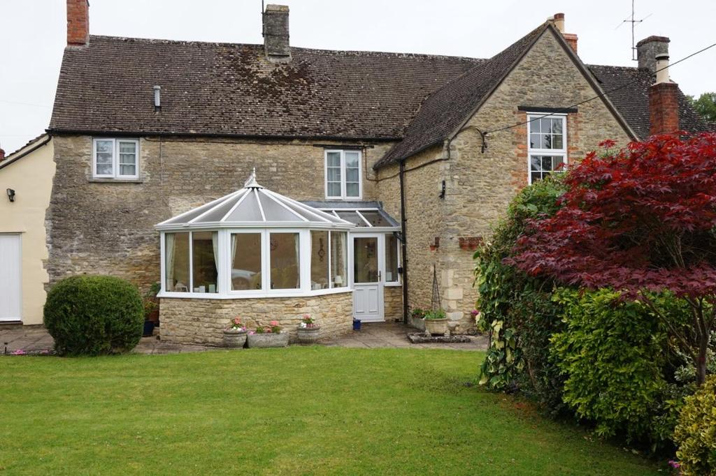a brick house with a conservatory in a yard at The Nurseries Bed and Breakfast Fairford in Fairford