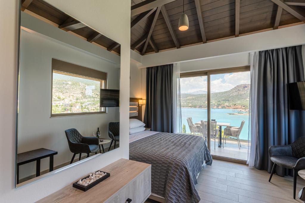 a hotel room with a bed and a view of the ocean at Lighthouse Apartments in Stoupa