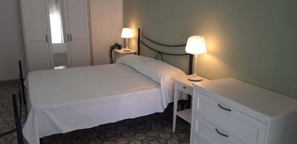 a bedroom with a bed and a desk with a lamp at Finestra sul porto in Marina di Camerota