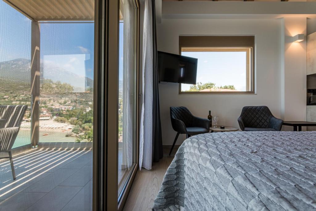 a bedroom with a bed and a large window at Lighthouse Apartments in Stoupa