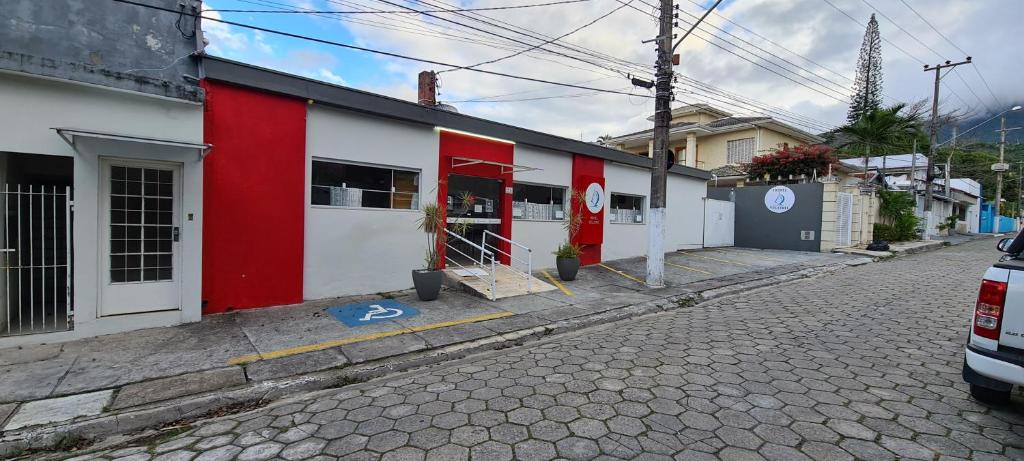 a red and white building on the side of a street at Hotel Veleiro in São Sebastião