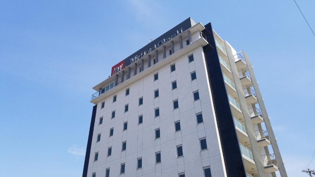 un edificio blanco con un cartel encima en MyHotel Okazaki, en Okazaki