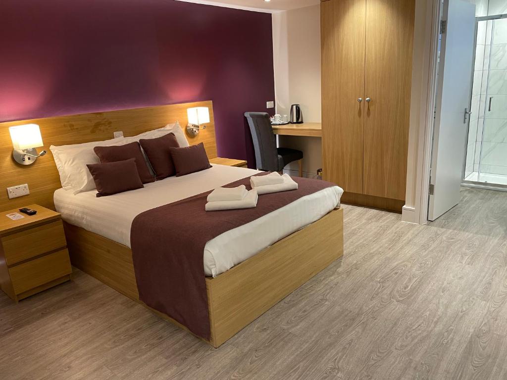 a bedroom with a large bed and a desk at Holtwhites Hotel in Enfield