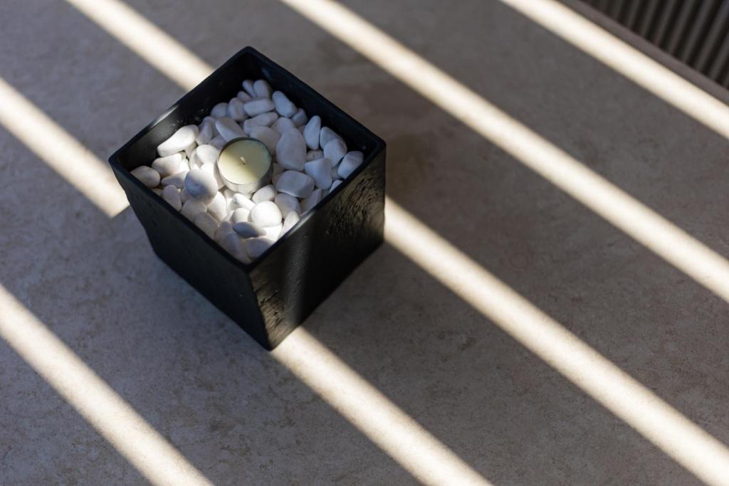 a black box filled with white rocks on a floor at Lighthouse Apartments in Stoupa