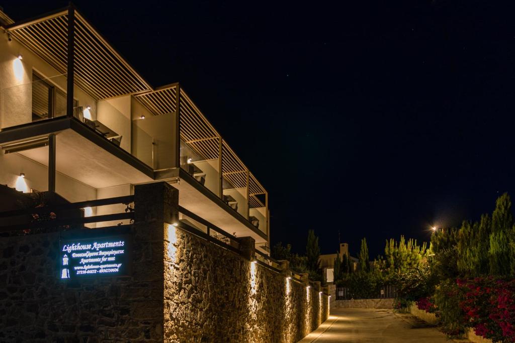a building with a sign on the side of it at night at Lighthouse Apartments in Stoupa