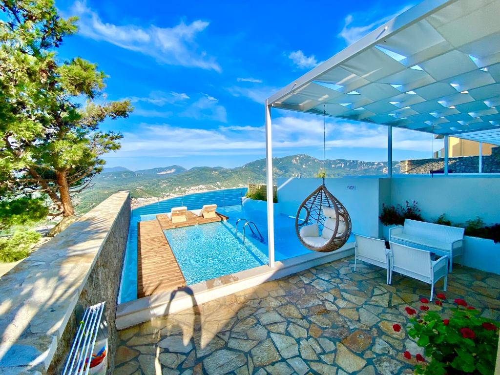 a villa with a swimming pool and a patio at Zeus Throne Suites in Afionas