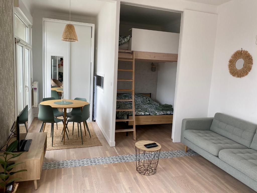 een woonkamer met een bank, een bed en een tafel bij Appart wimereux centre in Wimereux