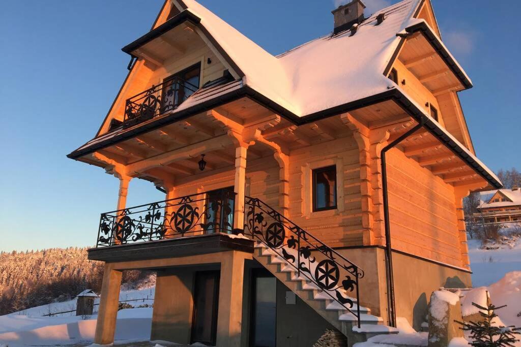 Cabaña con techo cubierto de nieve y balcón en Między Nami Góralami, domek na Podhalu, Gorce, en Huba