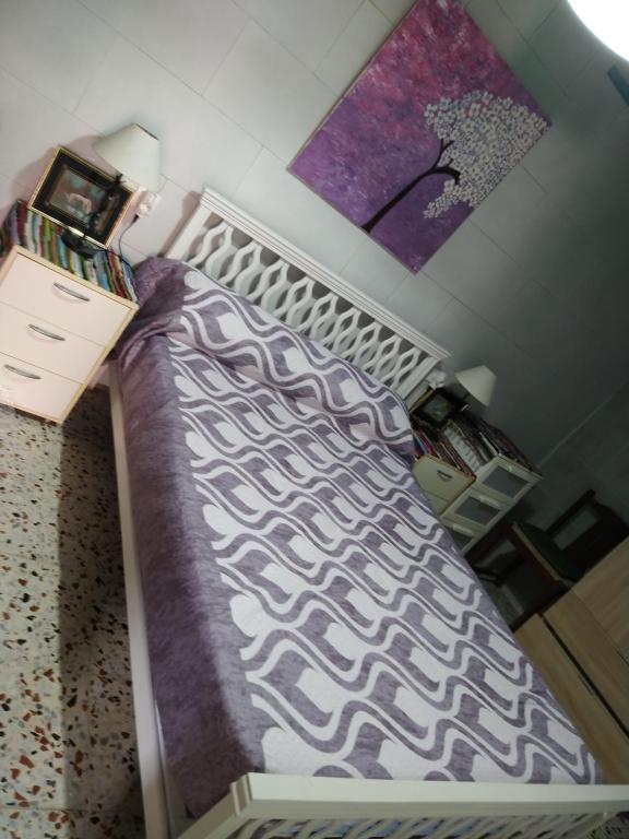 - une chambre avec un lit doté d'une couette violette et blanche dans l'établissement La casita, à Vejer de la Frontera