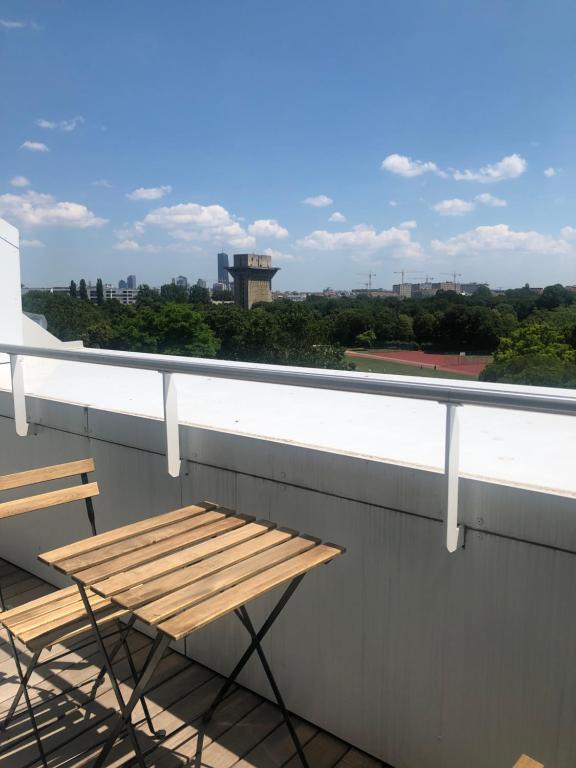 a table and chairs on a balcony with a view at Augartenblick Penthaus 17 - Blick zum Riesenrad in Vienna