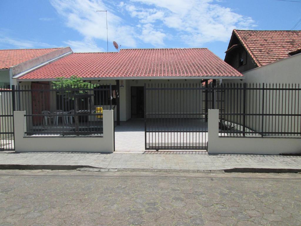 una puerta frente a una casa con techo rojo en CASA EM PENHA SC PERTO DO BETO CARRERO E DA PRAIA, en Penha