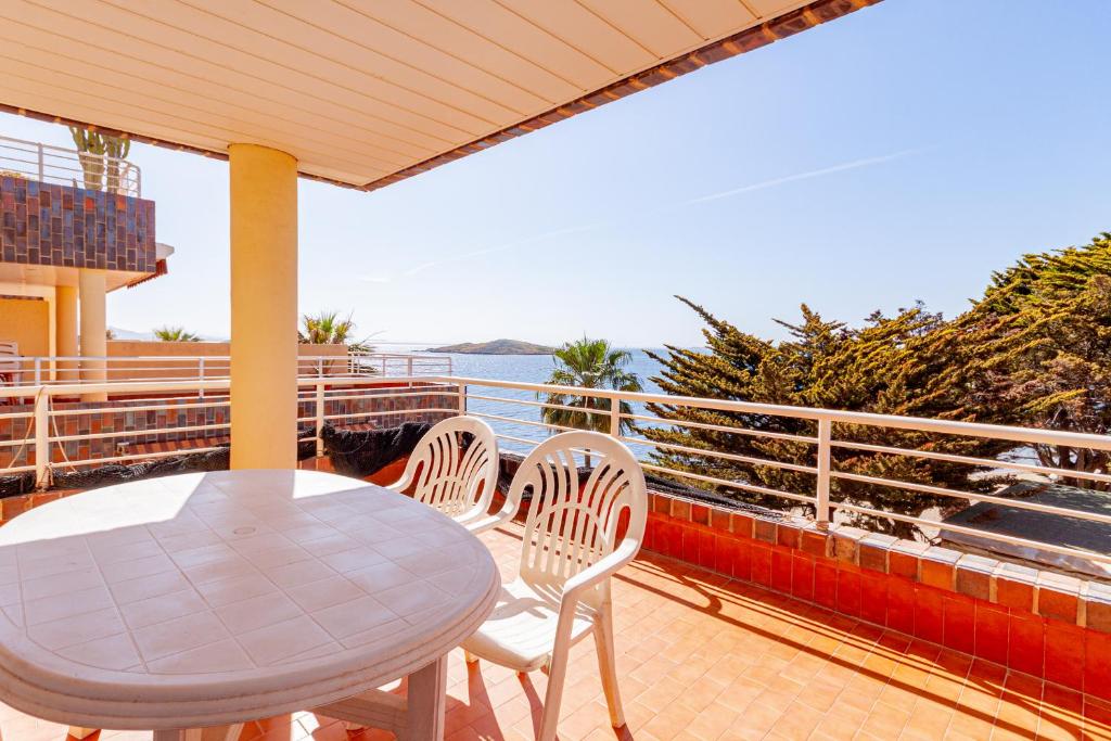 a table and chairs on a balcony with a view of the ocean at Arpon 8C in La Manga del Mar Menor