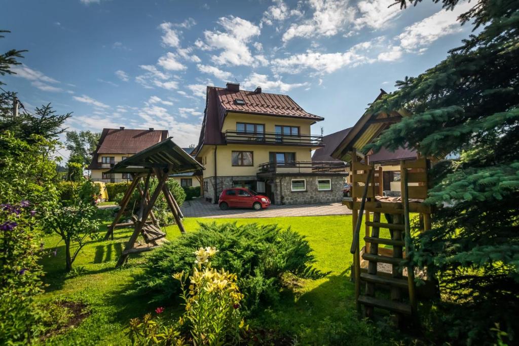 a house with a red car parked in a yard at U Capka in Poronin