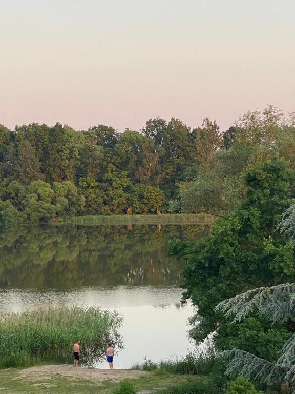 two people standing in front of a lake at Ferienwohnung am Teufelsmoor -KEINE MONTEURE- in Klein Wehnendorf