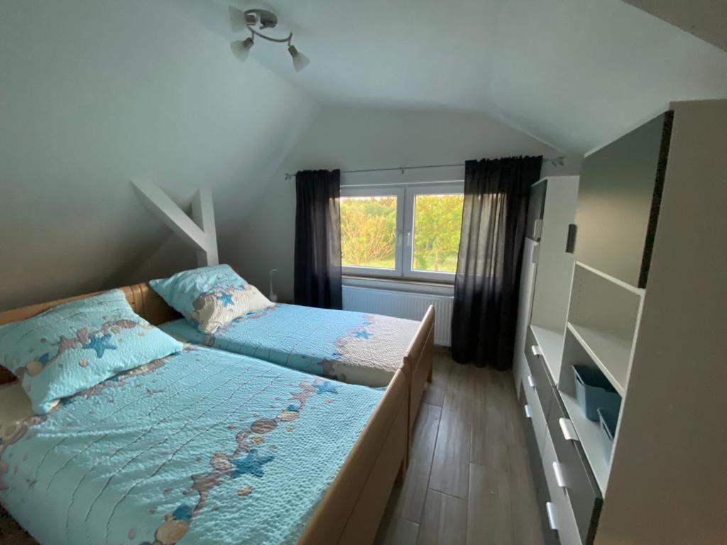um pequeno quarto com 2 camas e uma janela em Ferienwohnung am Teufelsmoor -KEINE MONTEURE- em Klein Wehnendorf