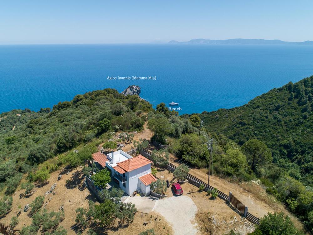 una vista aérea de una casa en una colina junto al océano en Villa Rose, en Glossa