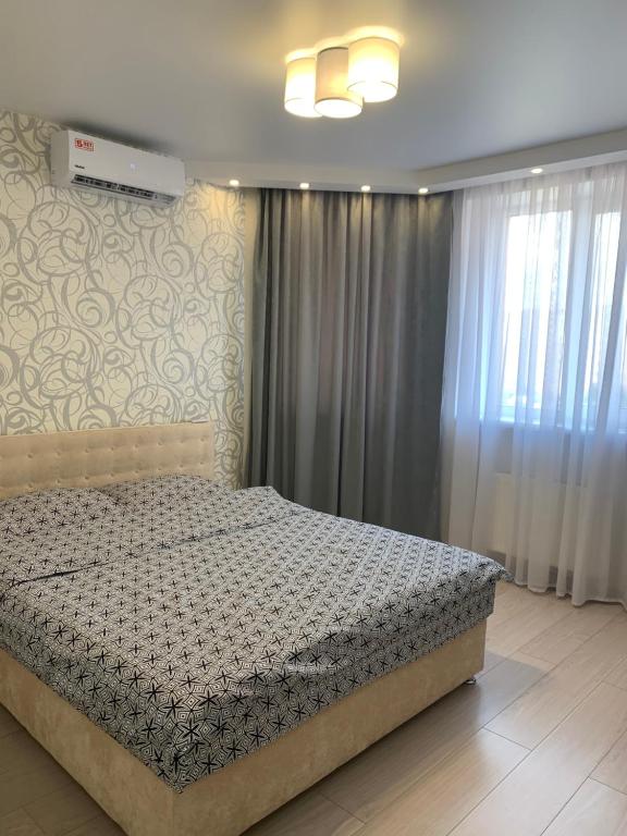 - une chambre avec un lit et une fenêtre avec des rideaux dans l'établissement 044 Квартира в ЖК "София", à Kiev