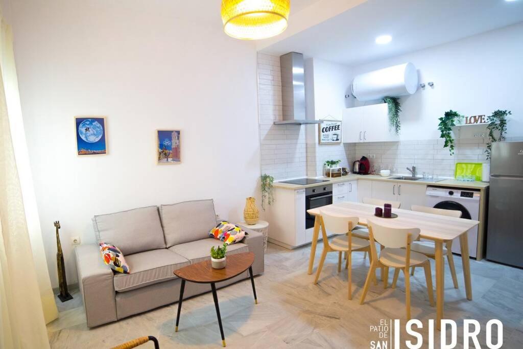 sala de estar con sofá, mesa y cocina en El patio de San Isidro by Gades Gestión, en Cádiz