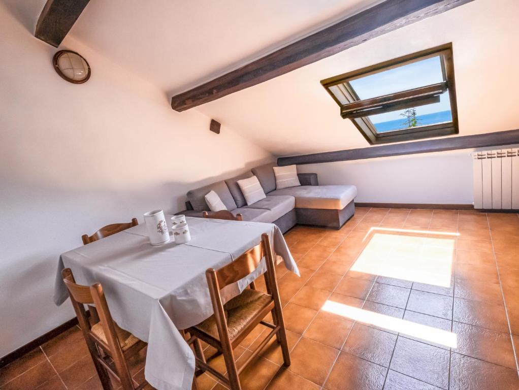 uma sala de jantar com uma mesa e um sofá em Tino Brezza di Mare em Deiva Marina