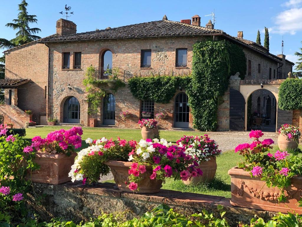 an old house with flowers in front of it at Agriturismo Macciangrosso Casale Piccolomini in Chiusi