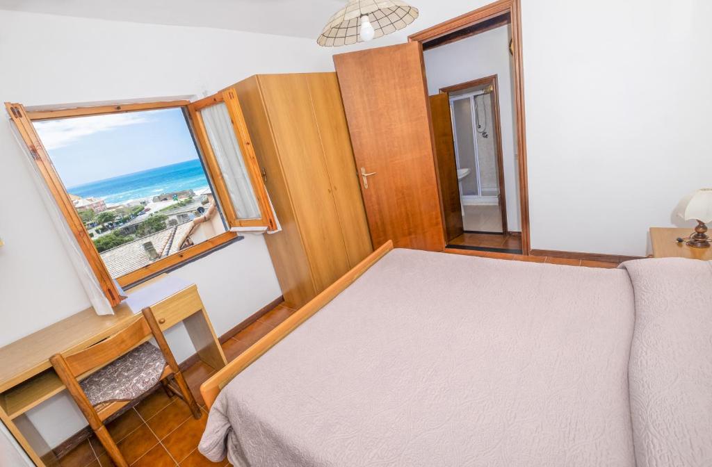 a bedroom with a bed and a view of the ocean at Tinetto Brezza di mare in Deiva Marina