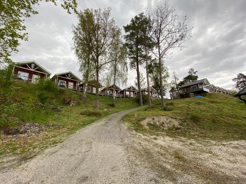 un camino de tierra delante de una fila de casas en Visitor Stugby en Håverud