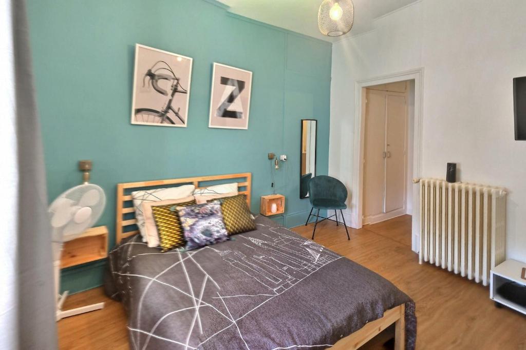 1 dormitorio con cama y pared azul en T1 le Pastel Parking Netflix Wifi Gare en Évreux