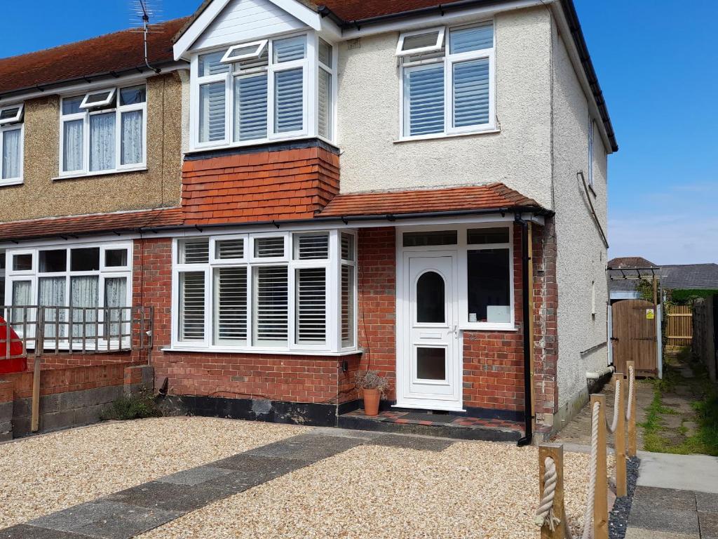 Casa de ladrillo con puerta blanca y ventanas en 32 Cranleigh Close en Bournemouth