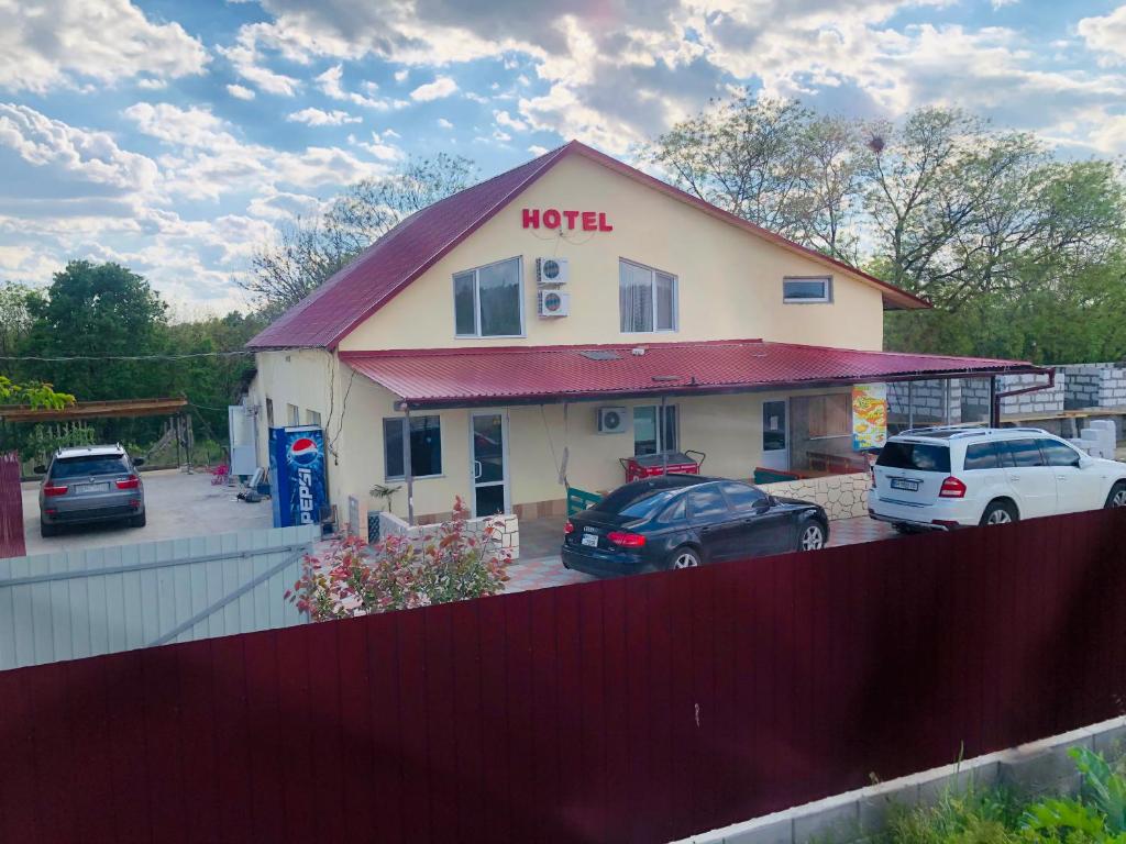 a motel with cars parked in a parking lot at Гостиный Дом Comfort in Reni