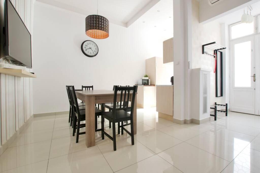 a dining room with a table and chairs and a clock at Premium Apartment by Hi5-Vaci str. 3 bedroom (218) in Budapest