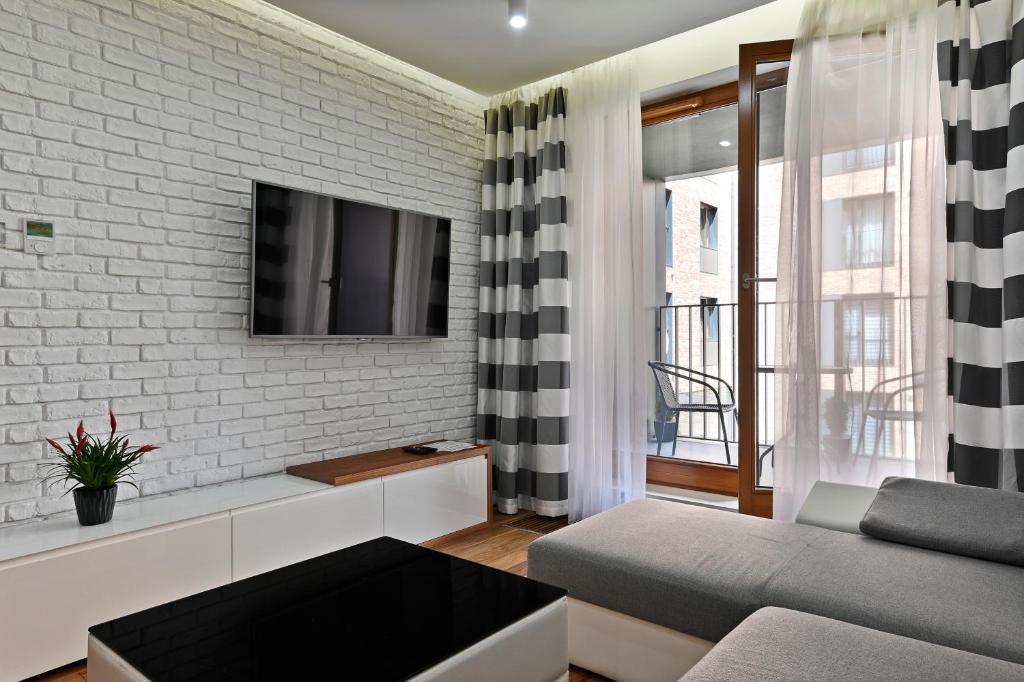 Televízia a/alebo spoločenská miestnosť v ubytovaní Apartamenty Prestige Browar Lubicz Stare Miasto