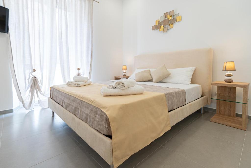 1 dormitorio con 1 cama grande y toallas. en Lighthouse Apartment en Taormina