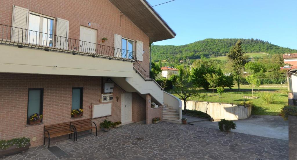 ein Gebäude mit einem Balkon und einer Bank daneben in der Unterkunft B&B Canavaccio in Urbino