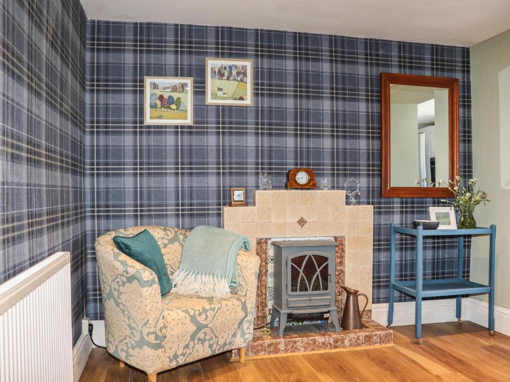 a living room with a chair and a fireplace at East Hill Farm in Truro