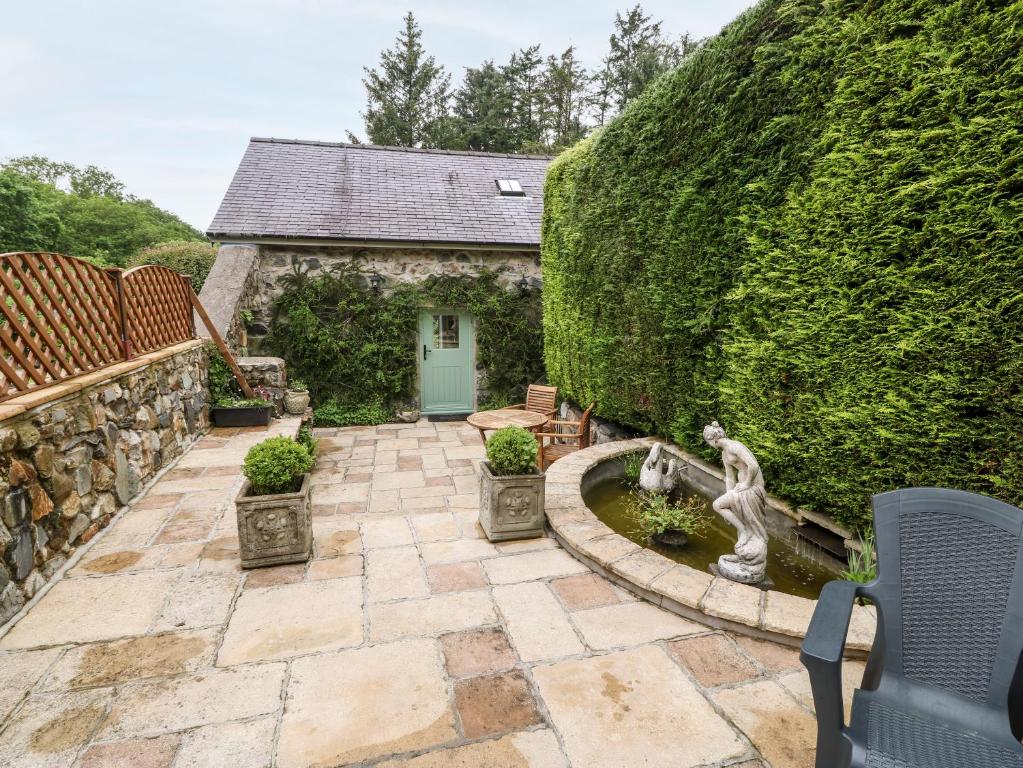 un giardino con fontana di fronte a un edificio di The Little Coach House a Brynkir