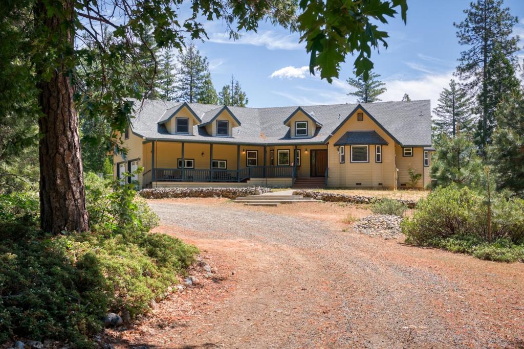 a large yellow house with a gravel driveway at Moonrise Lodge - A Large Vacation Home in Mariposa in Mariposa