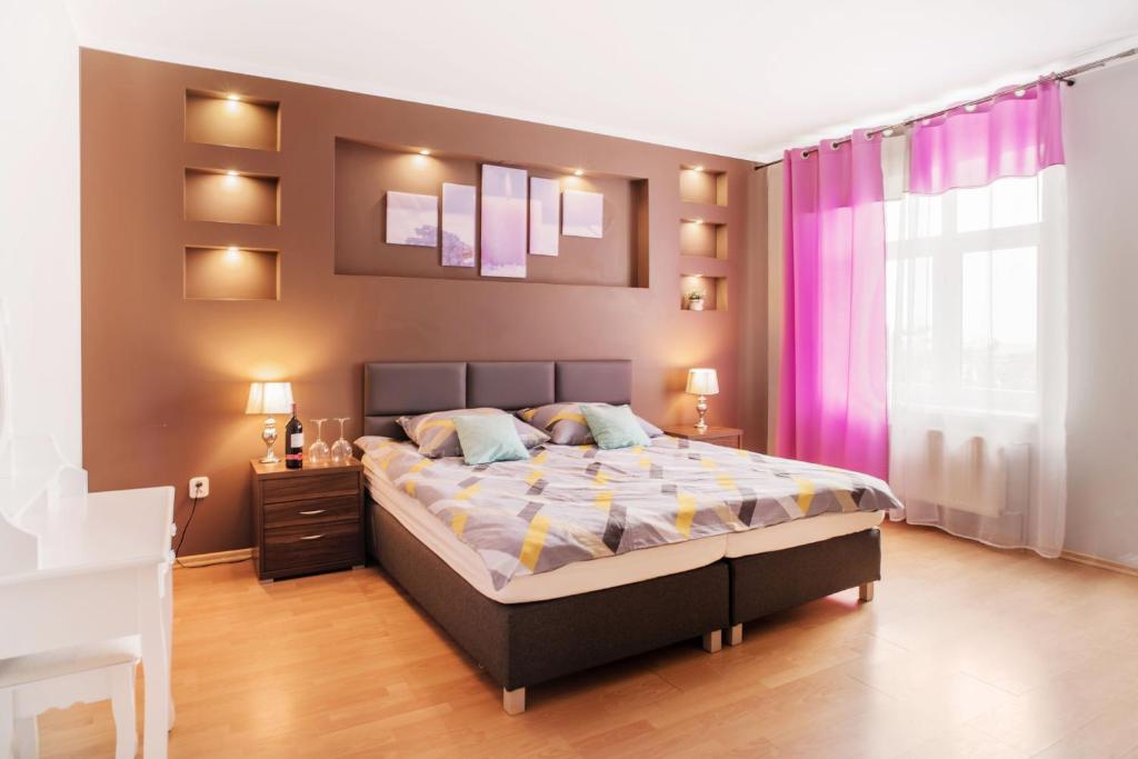 1 dormitorio con 1 cama grande y paredes moradas en Lawendowy Dworek en Karpacz