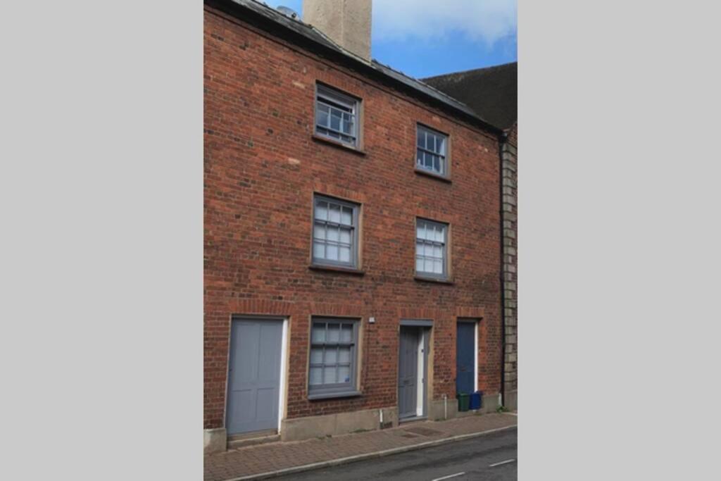 un edificio de ladrillo con puertas blancas en una calle en Grade II listed, town house, en Monmouth