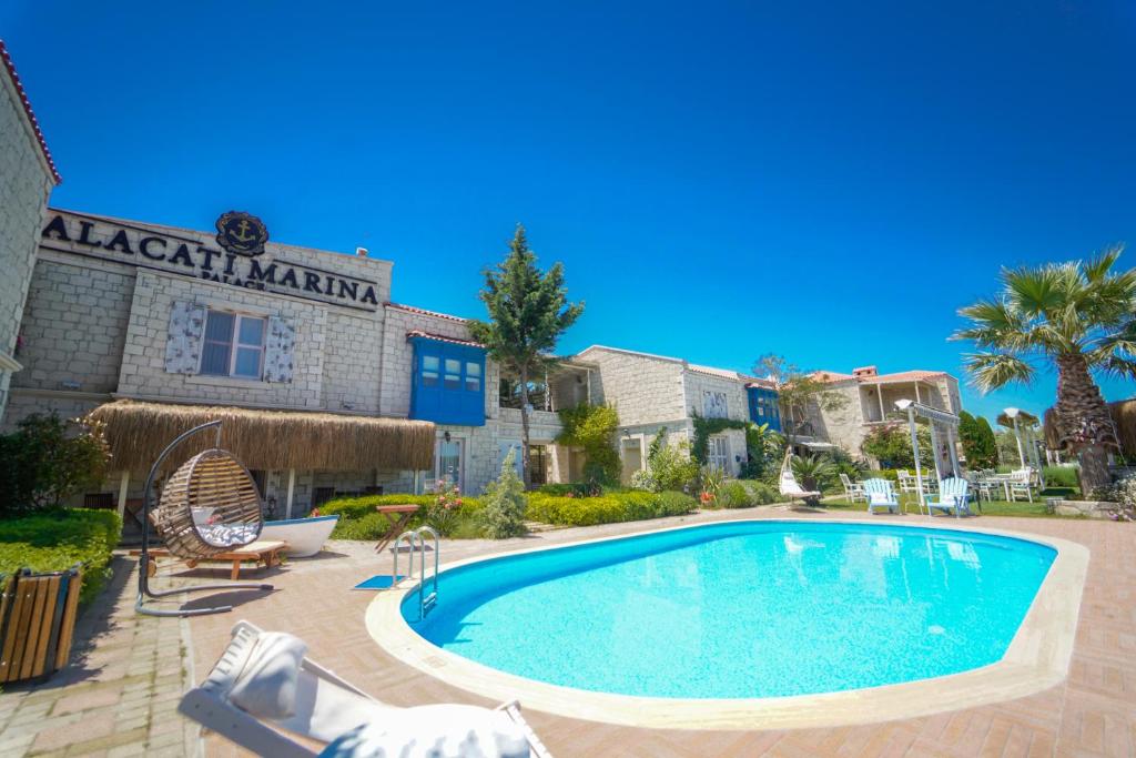 a swimming pool in front of a building at Alacati Marina Palace in Alacati