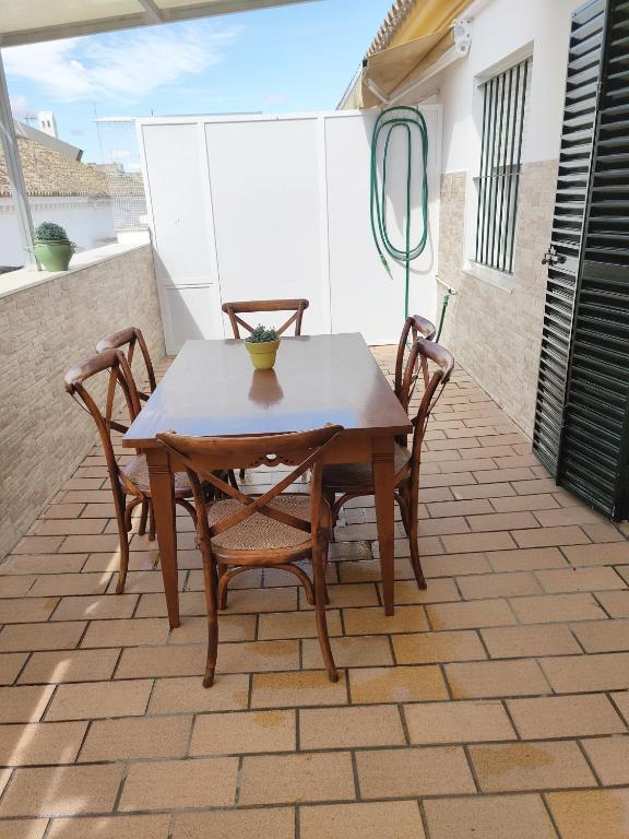 a wooden table and chairs on a patio at Apartamento Nao Victoria in Sanlúcar de Barrameda