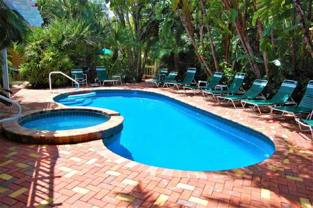 uma piscina com espreguiçadeiras ao lado em Siesta Palms By the Beach em Sarasota