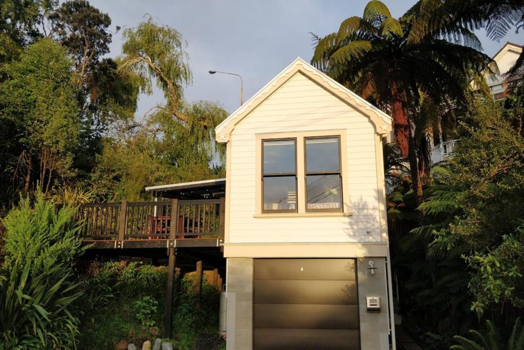 a small house with a garage door and a window at Tiny House in the Sky in Dunedin