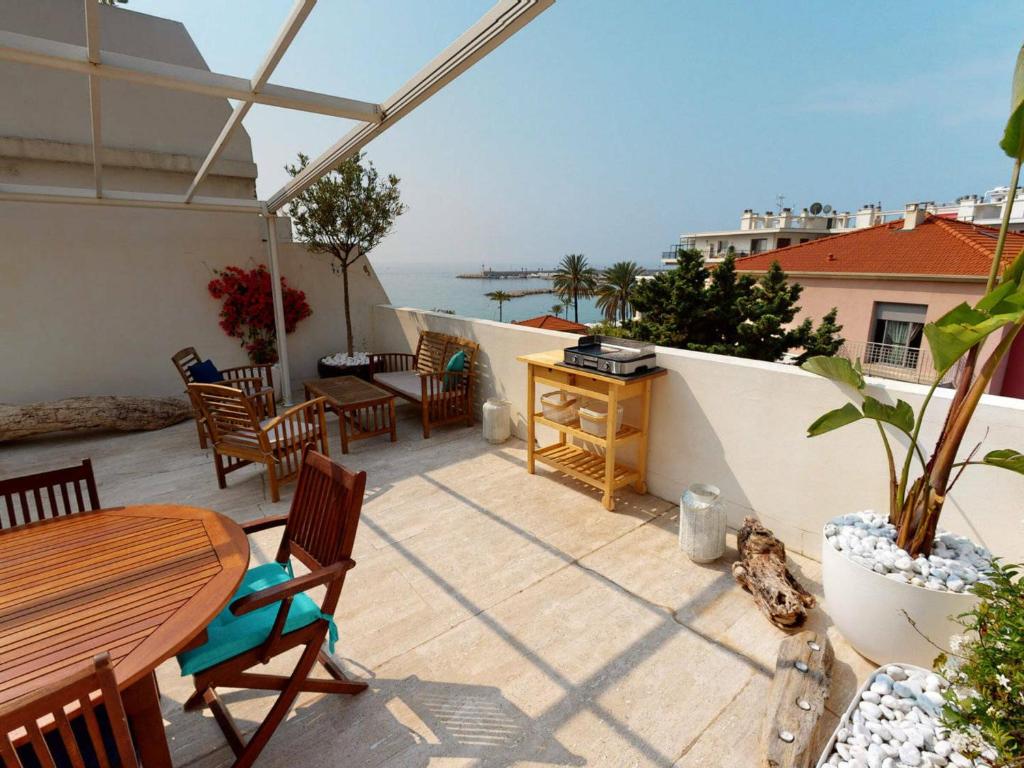 a patio with a table and chairs and the ocean at Appartement Menton, 3 pièces, 5 personnes - FR-1-196-290 in Menton