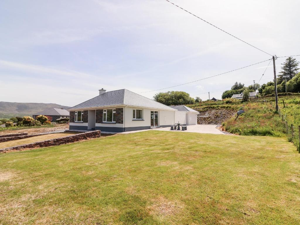 una casa con un gran césped delante de ella en Coolnaharragill Lower, en Killarney