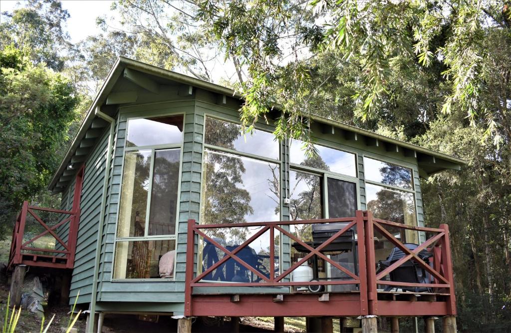 a green tree house with a large window at Karinya "Peaceful Home" in Bandon Grove