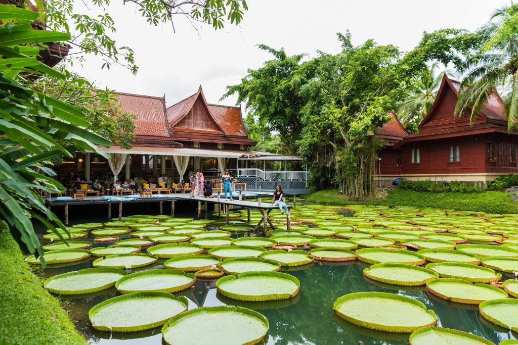 een tuin met lelies in het water voor een gebouw bij Ma Doo Bua Phuket - SHA Extra Plus in Thalang