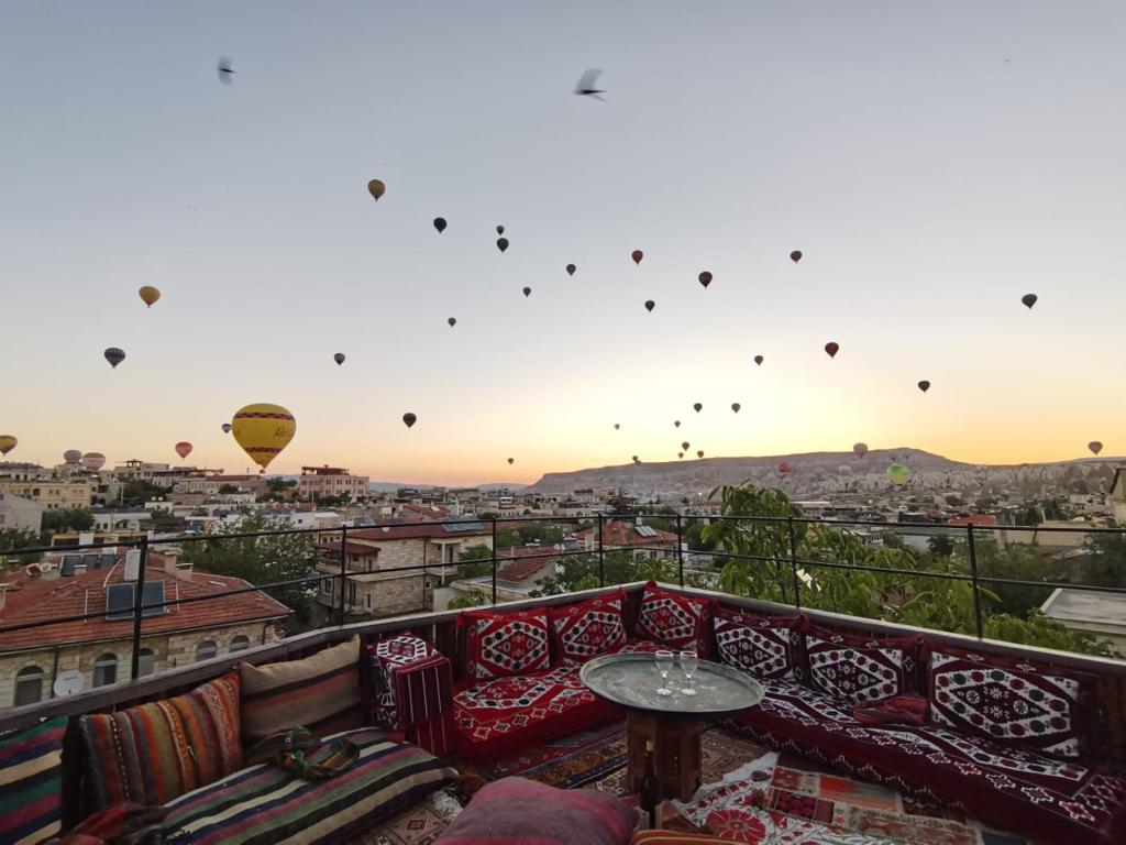 a balcony with a couch and hot air balloons in the sky at Old Town Stone House in Goreme